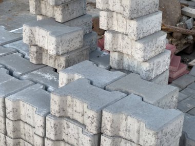İnşaat sahasında yığılmış gri beton kaldırımları kapatın. Yol veya veranda kurulumu için dayanıklı yapı malzemeleri hazır.