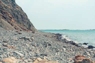 Mavi dalgaların kırıldığı denizin şöminesi. Ufuk çizgisi ve mavi gökyüzü olan mavi deniz manzarası. Güneşli sıcak bir günde mavi deniz ve mavi gökyüzü manzarası. Sıcak denizin yumuşak deniz dalgaları güneşli bir günde kıyıya vurur..