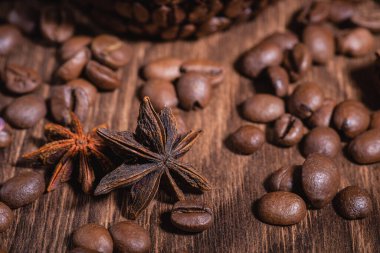 Arka planda koyu renkli kahve çekirdekleri için arka plan. Kahve çekirdeği tarçın çubuğu Anise yıldız ahşap masa yakın çekim.