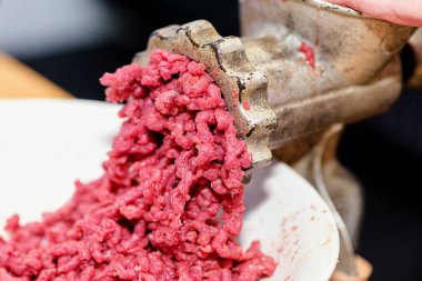  Kıymalı et. Kadının elleri, kıyma makinesinin içinden kıyma çıkan elle bükülür.. 