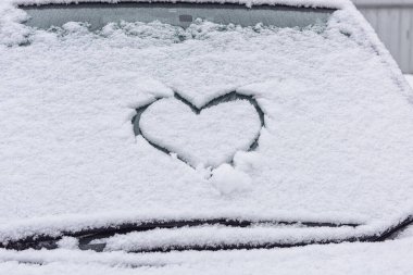 Ön camda karın kalbi var. Kar kalbi. Sevgililer günü cama. Kar, kalp, soğuk bir gün..
