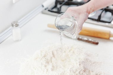 El şefi pizza için hamur yoğurdu. Ellerinle hamur yoğur. Kadın eli hamuru yoğurur. Pizza pişiriyorum.. 