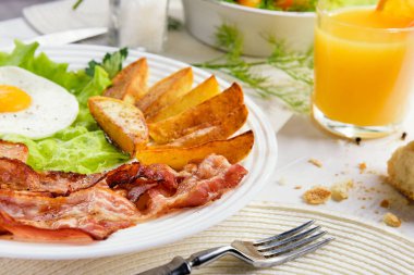 Fast food kafede nefis, altın kabuklu patates kızartması. Sağlıksız, ama lezzetli ve sağlıksız yiyecekler. Pastırmalı ve yumurtalı kızarmış patates çubukları..