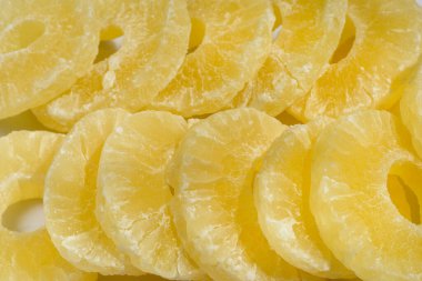 Kurutulmuş ananas şekeri halkaları, pudra şekerli, güneş ışığında yakın plan..