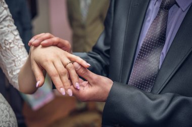 Genç gelin ve damat düğün sırasında yüzüklerini takıyorlar..