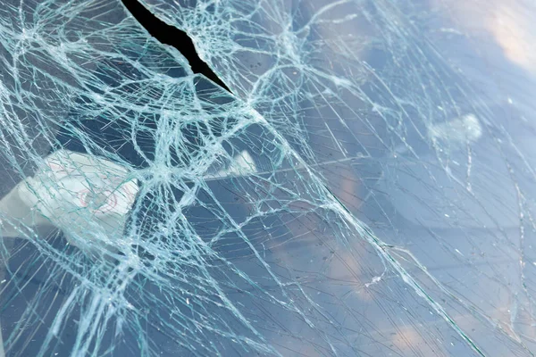 The broken windshield near the car. Car with broken glass after an accident.
