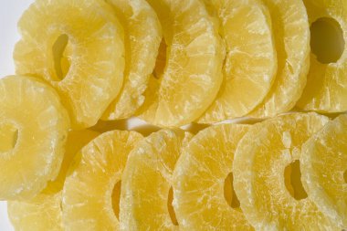 Ananas dilimleri. Kurutulmuş ananas şekeri halkaları, pudra şekerli, güneş ışığında yakın plan..