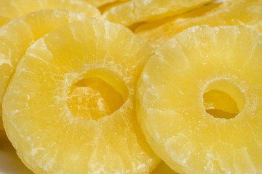 Kurutulmuş ananas şekeri halkaları, pudra şekerli, güneş ışığında yakın plan..