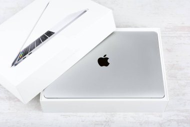 BURGAS, BULGARIA - AUGUST 31, 2017: MacBook Pro Retina Display with Touch bar and a Touch ID sensor integrated into the Power button, made by Apple Inc. on white wooden background.