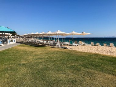 Nikiti plaj şezlong ve şemsiye ile Nikiti köyünde, Sithonia yarımadası, Chalkidiki, Orta Makedonya, Yunanistan
