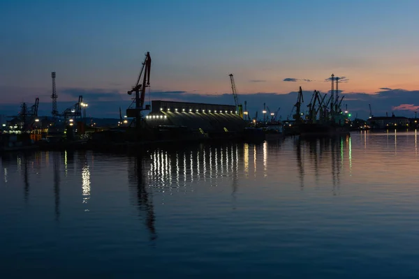 Burrgas port morski w nocy. Sylwetki żurawi i refleksje w wodzie — Zdjęcie stockowe