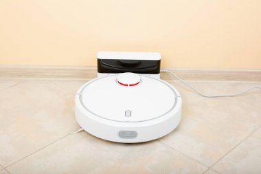 Oturma odasında cilalı granit zemin üzerinde elektrikli süpürge robot