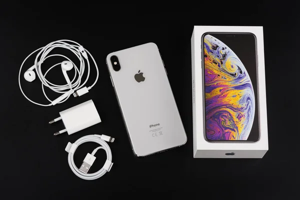 Burgas, Bułgaria-8 listopada 2018: Apple iPhone XS Max srebrny na czarnym tle, widok z tyłu. Ładowarka, EarPods i akcesoria do adapterów — Zdjęcie stockowe