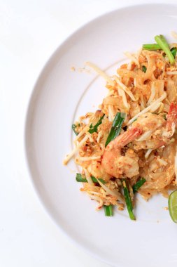 Pad Thai, tavada kızartılmış Pirinç Noodle ile beyaz tabak karides ile slayt limon ve yeşil sebze. Tayland'ın ulusal ana yemek biri. Tayland popüler gıda. Tayland kızarmış noodle