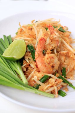 Pad Thai, tavada kızartılmış Pirinç Noodle ile beyaz tabak karides ile slayt limon ve yeşil sebze. Tayland'ın ulusal ana yemek biri. Tayland popüler gıda. Tayland kızarmış noodle
