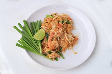 Pad Thai, tavada kızartılmış Pirinç Noodle ile beyaz tabak karides ile slayt limon ve yeşil sebze. Tayland'ın ulusal ana yemek biri. Tayland popüler gıda. Tayland kızarmış noodle