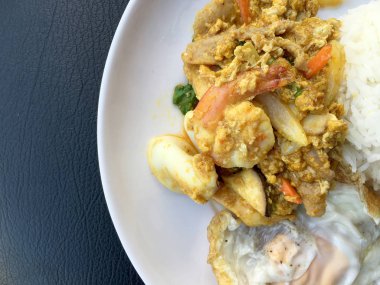 Stir fry karides ve köri güç Tay tarzında siyah kumaş doku arka plan üzerinde beyaz tabak pirinç kızarmış yumurta ile kalamar. Tay tarzında gıda.