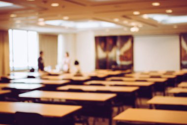 Modern konferans salonu ya da seminer odası masa ve sandalye toplantıdan önce arka plan bulanık görüntü. Konferans salonu ya da salonu veya sınıf boş koltuk sırasının bulanıklık. Vintage rengi.