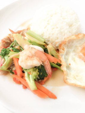 Kızarmış lezzetli shimp ve kızarmış yumurta beyaz arka plan üzerinde beyaz tabak pirinç Tay ev yapımı yemek ya da restoranda yemek tarifi olarak hizmet ile karışık sebze sote. Tay tarzında gıda.