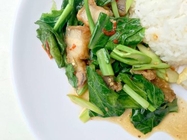 Fry stir Kai arazi ve gevrek domuz eti, beyaz arka plan üzerinde beyaz tabak kızarmış pilav pilav ile karıştırın. Tay tarzında gıda.