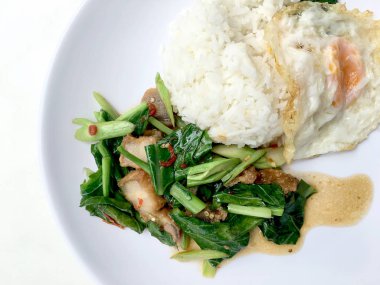 Fry stir Kai arazi ve gevrek domuz eti, beyaz arka plan üzerinde beyaz tabak kızarmış pilav pilav ile karıştırın. Tay tarzında gıda.