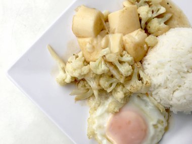 Karıştırın kızarmış Tofu Çin tarzı, derin kızarmış Tofu sosu soslu karnabahar ve Tay tarzında kızarmış yumurta beyaz arka plan üzerinde beyaz plaka ile tofu karıştırın kızarmış. Vejetaryen yiyecekler, sağlıklı gıda.