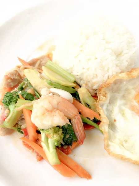 Kızarmış lezzetli shimp ve kızarmış yumurta beyaz arka plan üzerinde beyaz tabak pirinç Tay ev yapımı yemek ya da restoranda yemek tarifi olarak hizmet ile karışık sebze sote. Tay tarzında gıda.