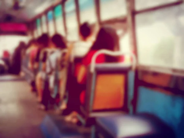 Abstract blurred image background of people on the bus at the morning in Thailand. view from inside with passengers of Bangkok. vintage and film tone effect.