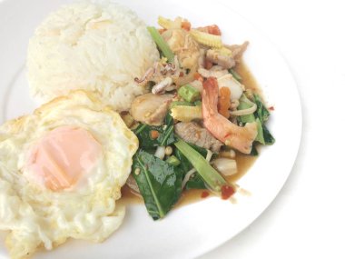 karışık sebze ve pirinç eski ahşap masa üzerinde beyaz tabak içinde Tay tarzında kızarmış yumurta ile tavada kızartılmış tavuk. Asya Tayland gıda.