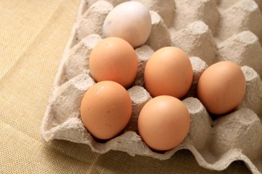 Kahvaltı hazırlama pişmiş yumurta omlet için otuz kutusu gazetede çiftlik taze tavuk yumurta yumurta kızarmış ve krem kumaş arka plan üzerinde yumurta için boş alana sahip.