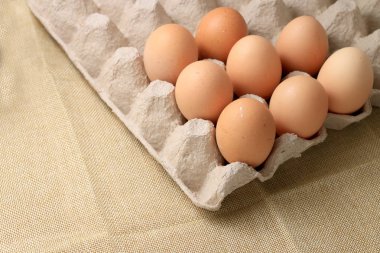 Kahvaltı hazırlama pişmiş yumurta omlet için otuz kutusu gazetede çiftlik taze tavuk yumurta yumurta kızarmış ve krem kumaş arka plan üzerinde yumurta için boş alana sahip.