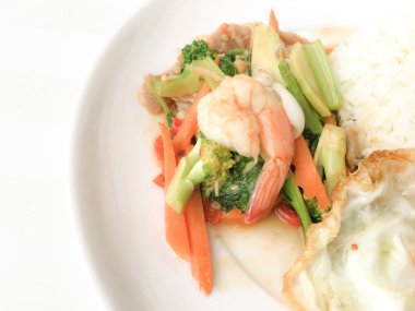 Kızarmış lezzetli shimp ve kızarmış yumurta beyaz arka plan üzerinde beyaz tabak pirinç Tay ev yapımı yemek ya da restoranda yemek tarifi olarak hizmet ile karışık sebze sote. Tay tarzında gıda.