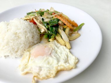 Beyaz arka plan üzerinde beyaz plaka karışımı sebze sos sos ve Tay tarzında kızarmış yumurta ile karıştırın. Vejetaryen yiyecekler, sağlıklı gıda.