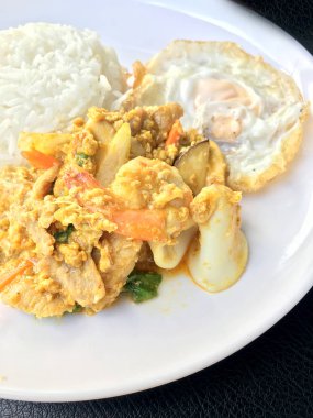 Stir fry karides ve köri güç Tay tarzında siyah kumaş doku arka plan üzerinde beyaz tabak pirinç kızarmış yumurta ile kalamar. Tay tarzında gıda.