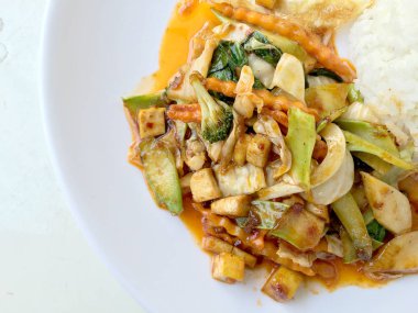 Ev yapımı mini tofu stir fry, sebze ve acılı pirinç ile yapıştırın ve kızarmış yumurta için beyaz arka plan üzerinde beyaz tabak içinde Çin yeni yılı festival kutlamak. Sağlıklı ve vejetaryen yemek. Tay tarzında.