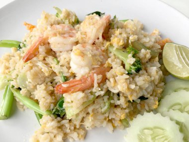 Limon ve beyaz arka plan üzerinde beyaz tabak içinde salatalık Fried rice karides otlar ve sebze ile servis. Dokuz Asya gıda yemekler bir dizi parçası. Tayland gıda.