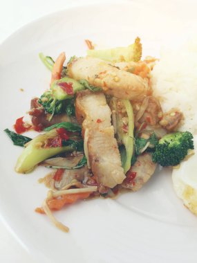 Kavrulmuş Chili Yapıştır ve karışık sebze soslu kızarmış gevrek domuz eti ilave edin; fesleğen; Kale; brokoli; havuç; kırmızı biber ve sahanda yumurta beyaz arka plan üzerinde beyaz tabak içinde Tayland Yasemin pirinç ile. Tay tarzında gıda.