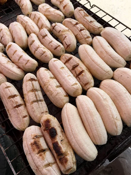 Close-up of grilled banana, Thai dessert in market, Roasting bananas on stove, Dessert by grilling banana on the hot charcoal, (Thailand traditional snacks/dessert). Street Food in Thailand, Vietnam