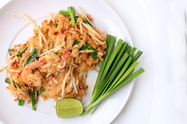 Pad Thai, stir-fried rice noodles with shrimp in white plate with slide lemon and green vegetable. The one of Thailand\'s national main dish. the popular food in Thailand. Thai Fried Noodles