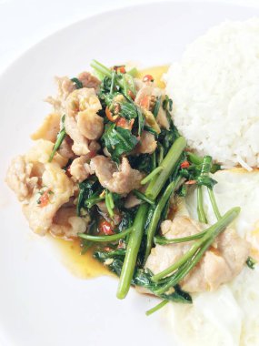 Fry stir Kai arazi ve gevrek domuz eti, beyaz arka plan üzerinde beyaz tabak kızarmış pilav pilav ile karıştırın. Tay tarzında gıda.