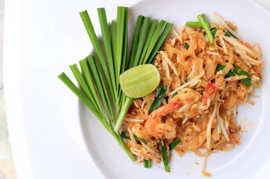 Pad Thai, tavada kızartılmış Pirinç Noodle ile beyaz tabak karides ile slayt limon ve yeşil sebze. Tayland'ın ulusal ana yemek biri. Tayland popüler gıda. Tayland kızarmış noodle