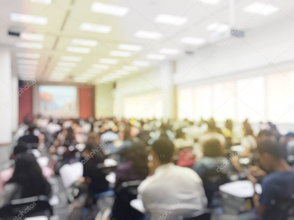 Education concept, Abstract blurred background image of students and business people  studying and discuss in large hall profession seminar with screen and projector for showing information.