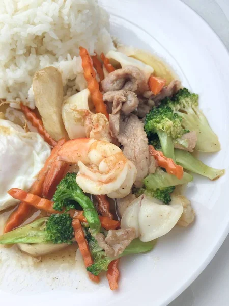 Sayuran aduk-goreng dengan tahu hwa dan udang dalam hidangan putih dengan nasi dan telur goreng di latar belakang kayu. Makanan gaya Thailand . — Stok Foto