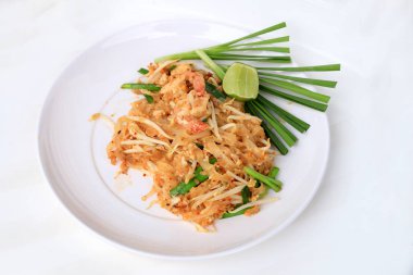 Pad Thai, tavada kızartılmış Pirinç Noodle ile beyaz tabak karides ile slayt limon ve yeşil sebze. Tayland'ın ulusal ana yemek biri. Tayland popüler gıda. Tayland kızarmış noodle