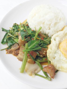 Kale ve Tay tarzı ile tavada kızartılmış gevrek domuz eti yumurta beyaz arka plan üzerinde beyaz tabak içinde kızarmış. Tay tarzında lokanta sıralama yapmak.