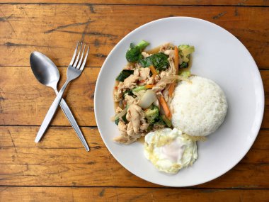 karışık sebze ve pirinç eski ahşap masa üzerinde beyaz tabak içinde Tay tarzında kızarmış yumurta ile tavada kızartılmış tavuk. Asya Tayland gıda.