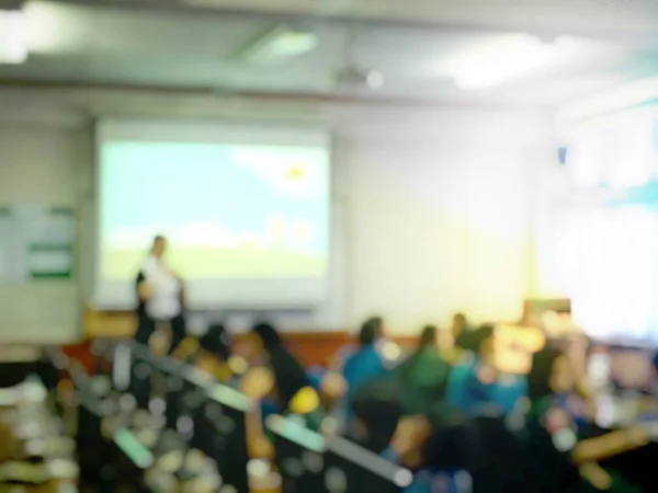 Immagine offuscata di persone di istruzione e uomini d'affari seduti in sala conferenze per il seminario di professione e l'oratore si presenta con proiettore schermo e condivisione di idee con l'attività di contenuto . — Foto Stock
