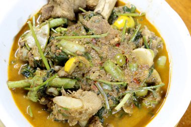 Domuz eti ve karışık sebze ve içinde ahşap masa üzerinde beyaz darbe Kuzey baharatlar, Krachan khae Tay kelime, Kuzey stili köri, Tayland Kuzey tarzı gıda Tay otlar ile Kuzey Tayland baharatlı köri.