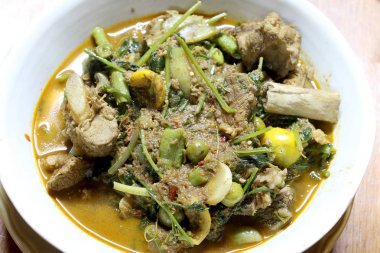 Domuz eti ve karışık sebze ve içinde ahşap masa üzerinde beyaz darbe Kuzey baharatlar, Krachan khae Tay kelime, Kuzey stili köri, Tayland Kuzey tarzı gıda Tay otlar ile Kuzey Tayland baharatlı köri.