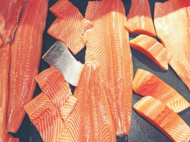 Çiğ somon dilimlenmiş veya taze somon. Somon fileto bir patchwork etkisi ile görüntülenen pazarında Satılık. Satılık süpermarket olan et dilimleri içinde siyah bir tepsi birçok taze somon balık.